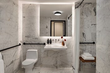 King Deluxe Mobility/Hearing Accessible with Roll-In Shower | Bathroom | Designer toiletries, hair dryer, bathrobes, slippers at The Chemists