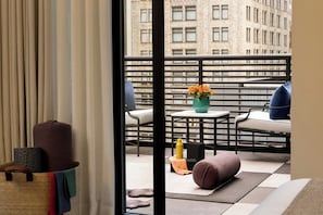 A balcony with a sofa, a small table, and a chair.