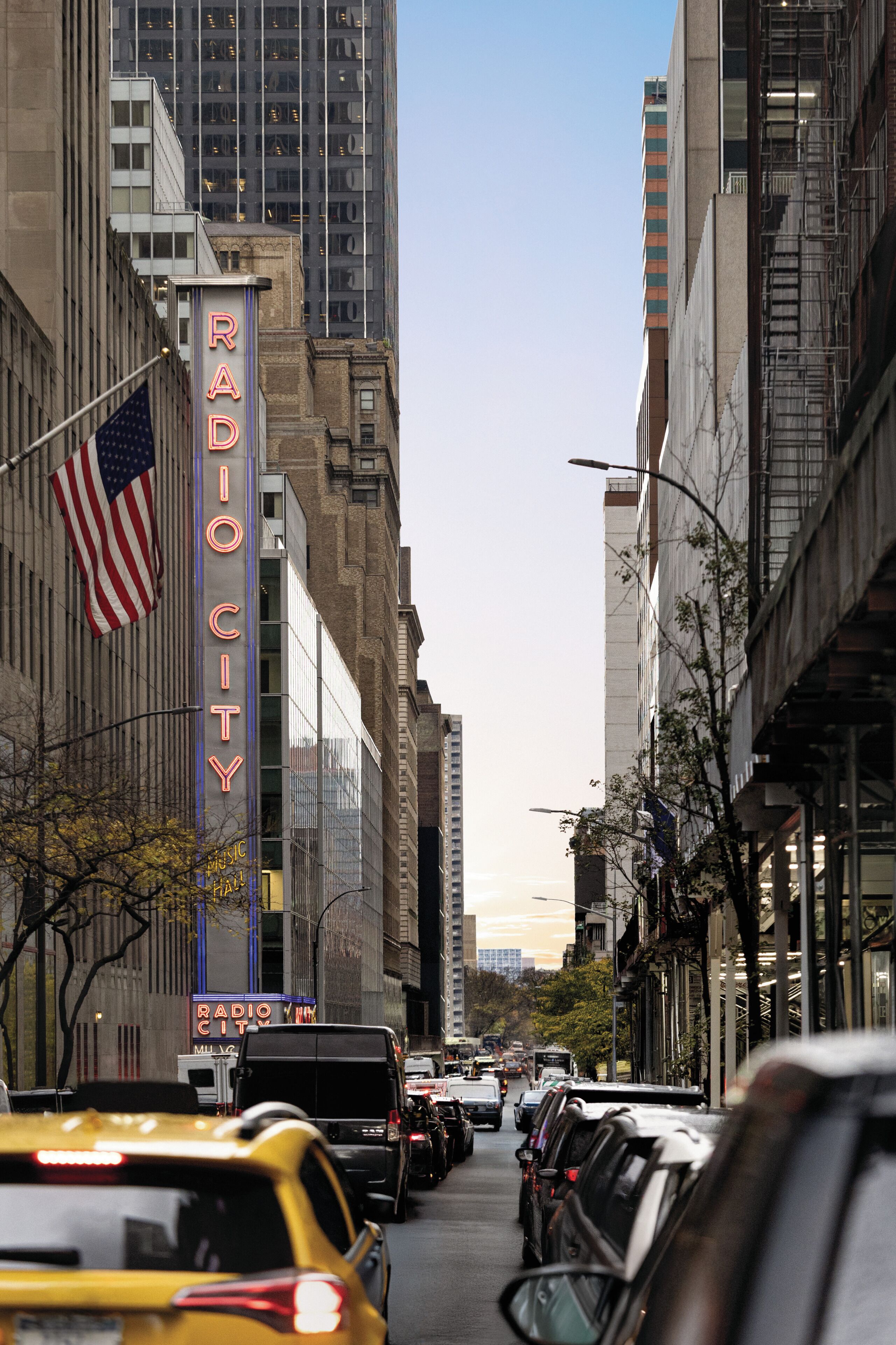 A street view with a building featuring a neon sign reading 'RADIO CITY.'