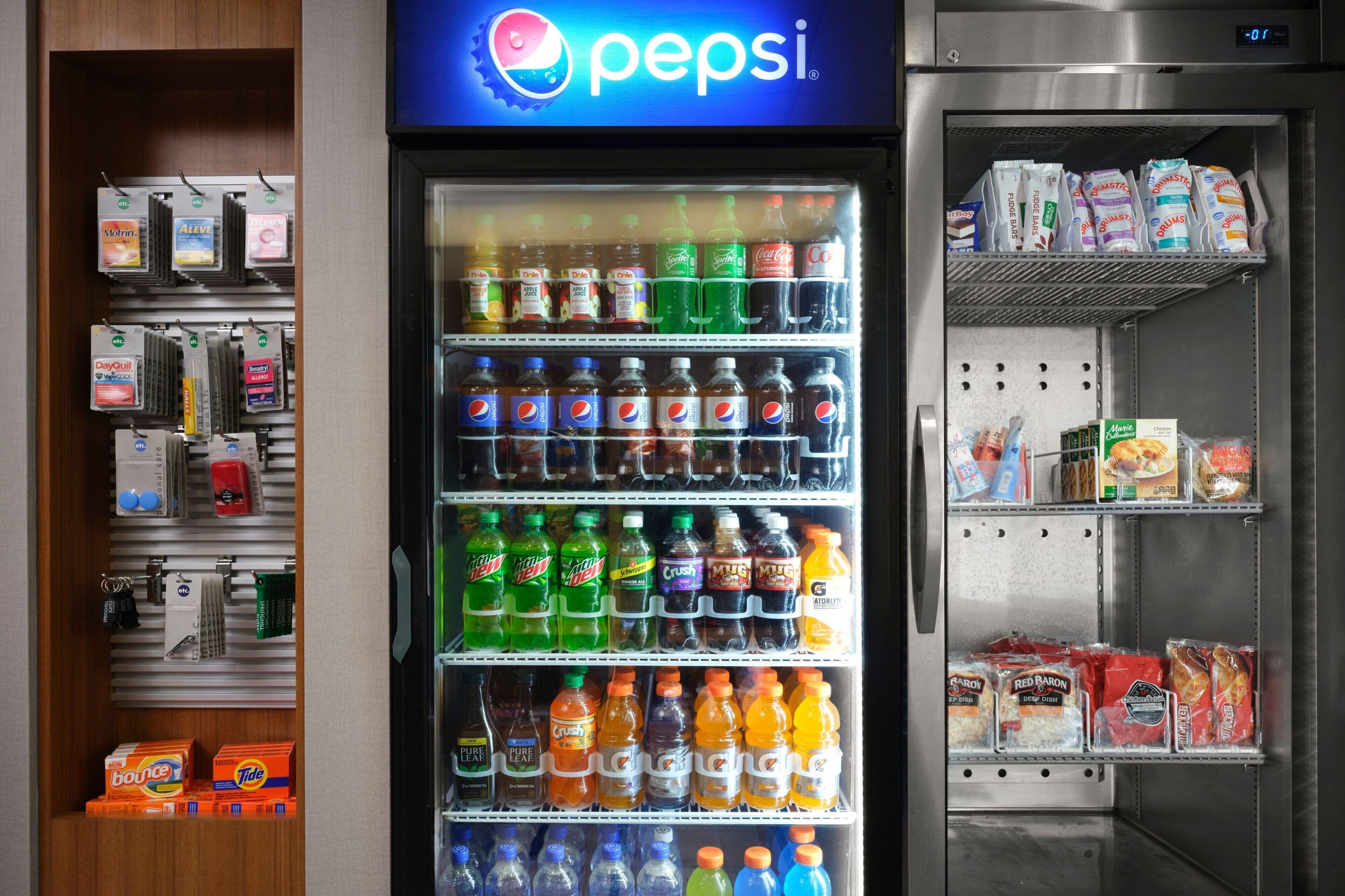 A vending machine stocked with various beverages and snacks, including brands like Pepsi, Mountain Dew, and Red Baron.