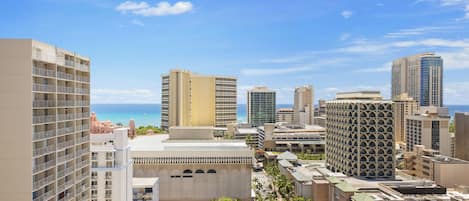 A cityscape with high-rise buildings, a clear sky, and a view of the ocean.