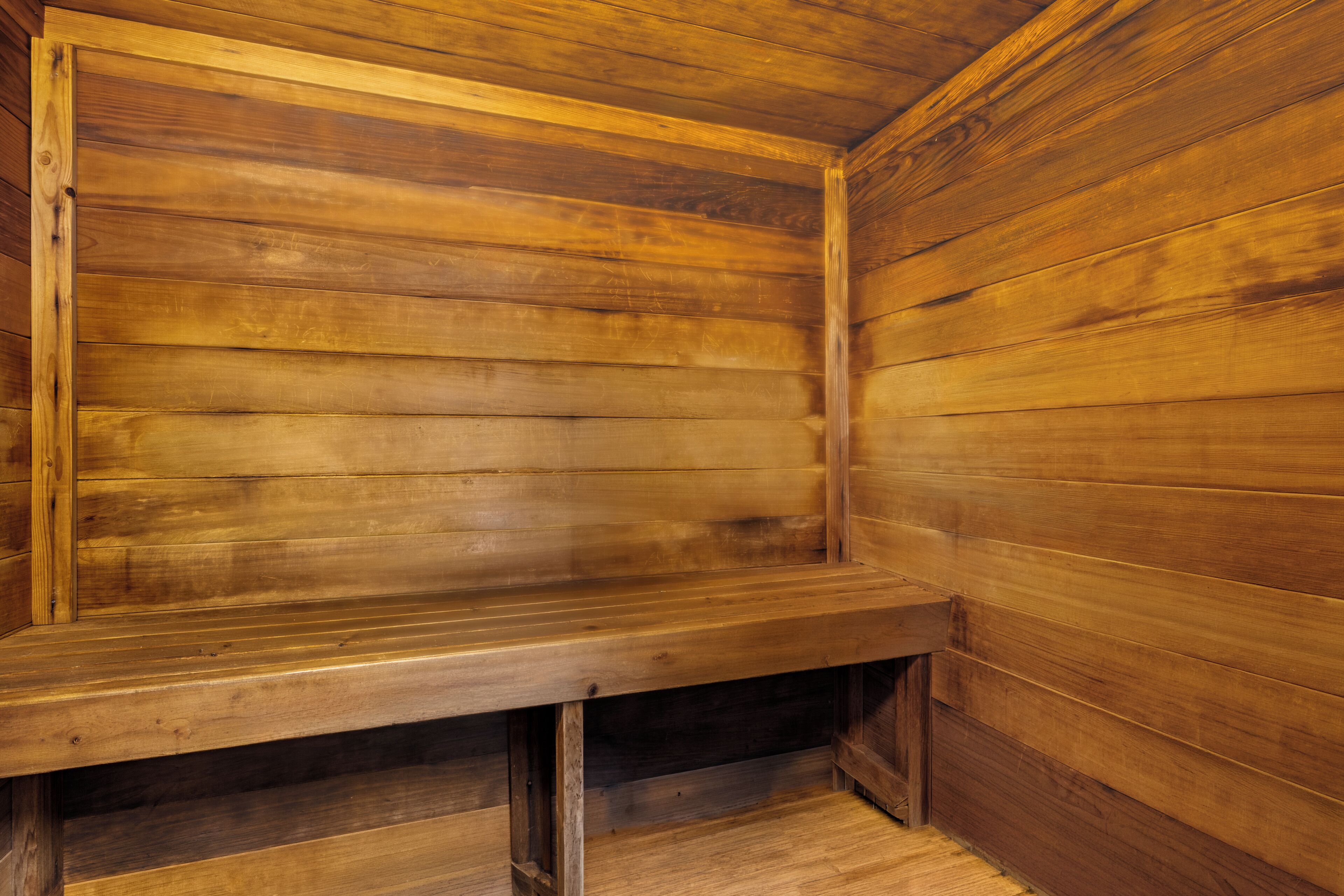 Un sauna en bois avec un banc et des bancs.