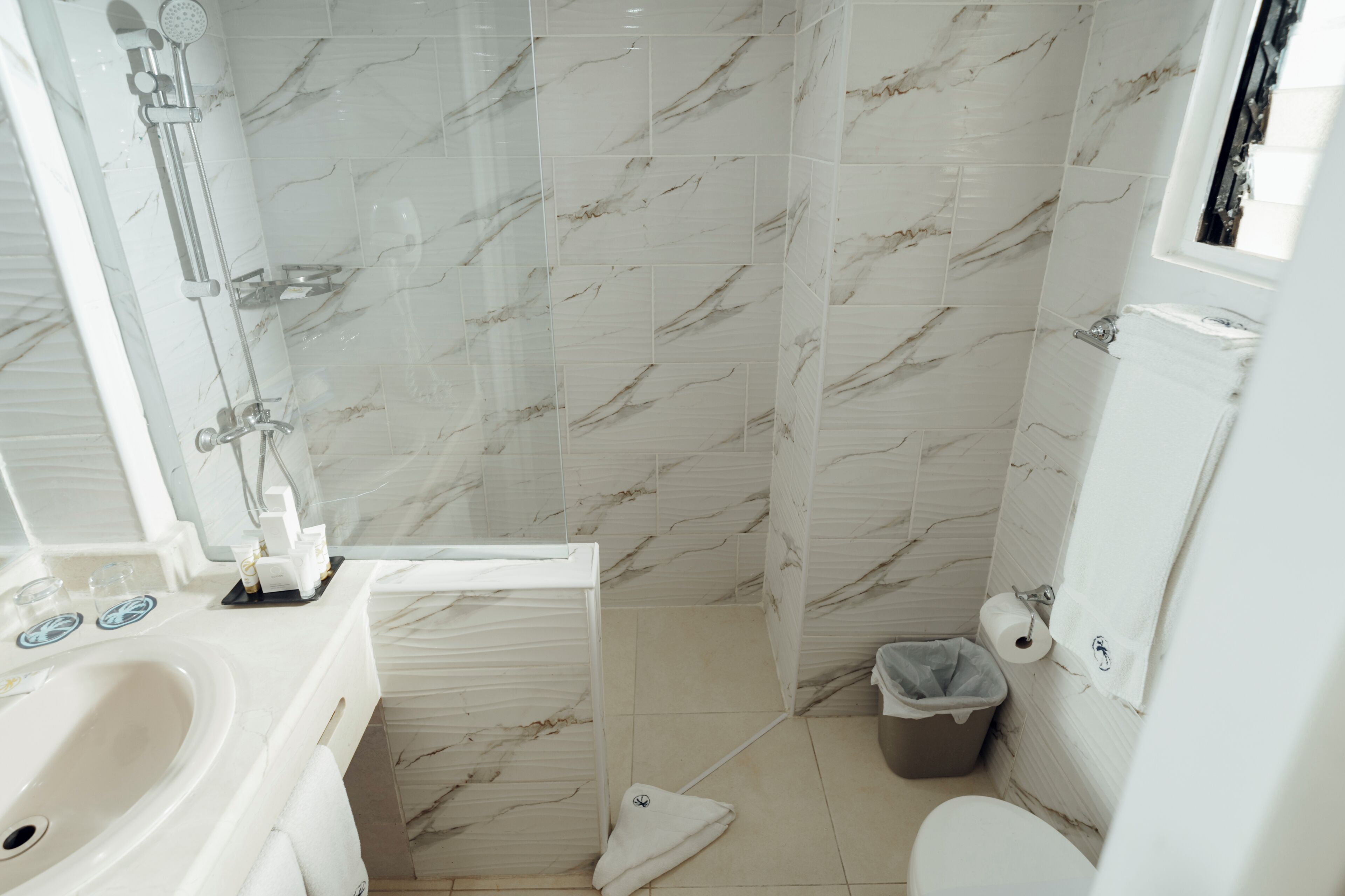 A bathroom with a shower, toilet, and sink.