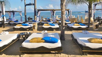 On the beach, white sand, sun-loungers, beach umbrellas