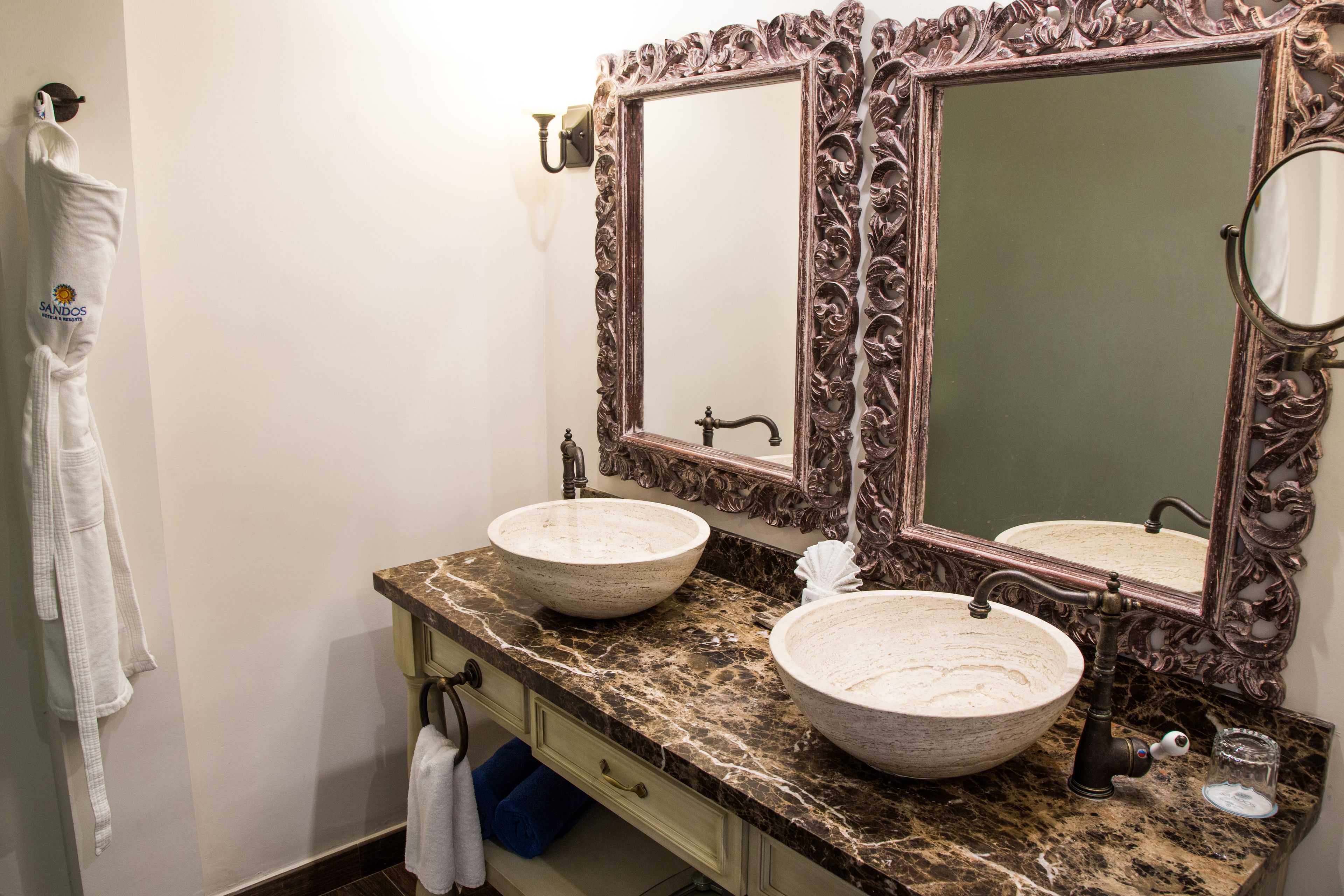 A bathroom with two sinks, a large mirror, and a towel rack.