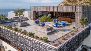 Una terraza en la azotea con mobiliario exterior y vistas al mar.
