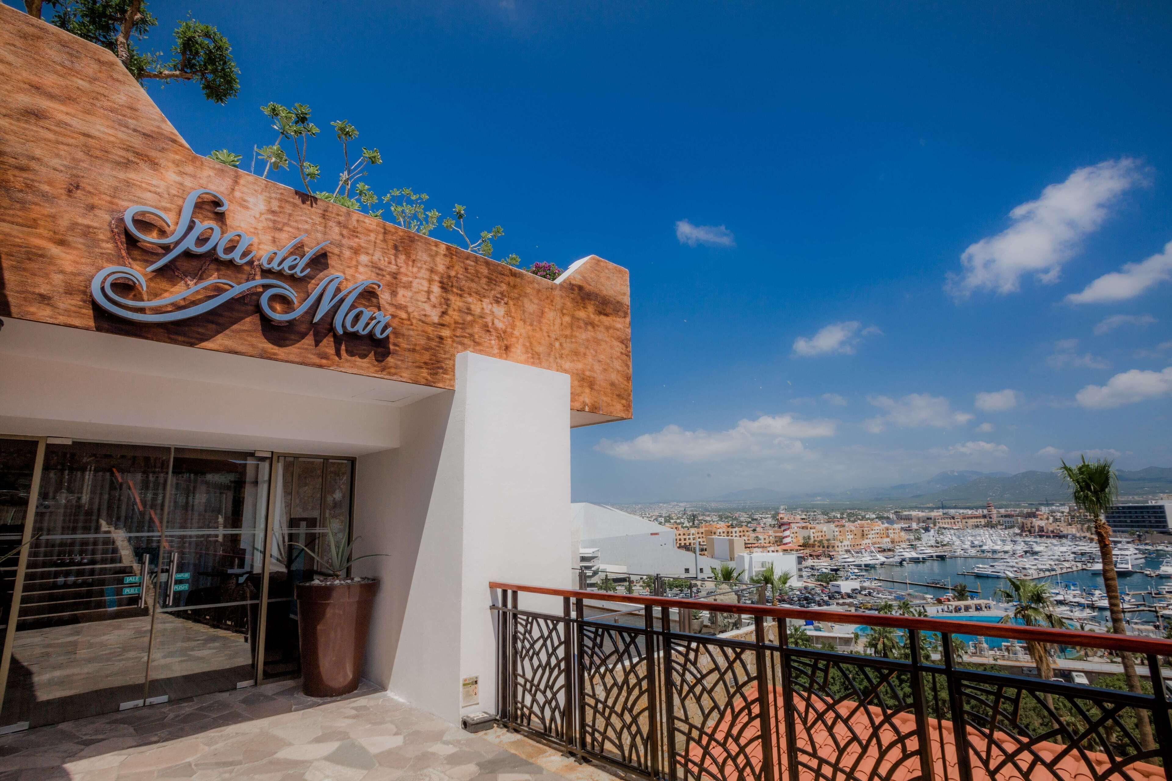 Un hôtel appelé « Spa del Mar », offrant une vue sur un port de plaisance et sur le paysage urbain.