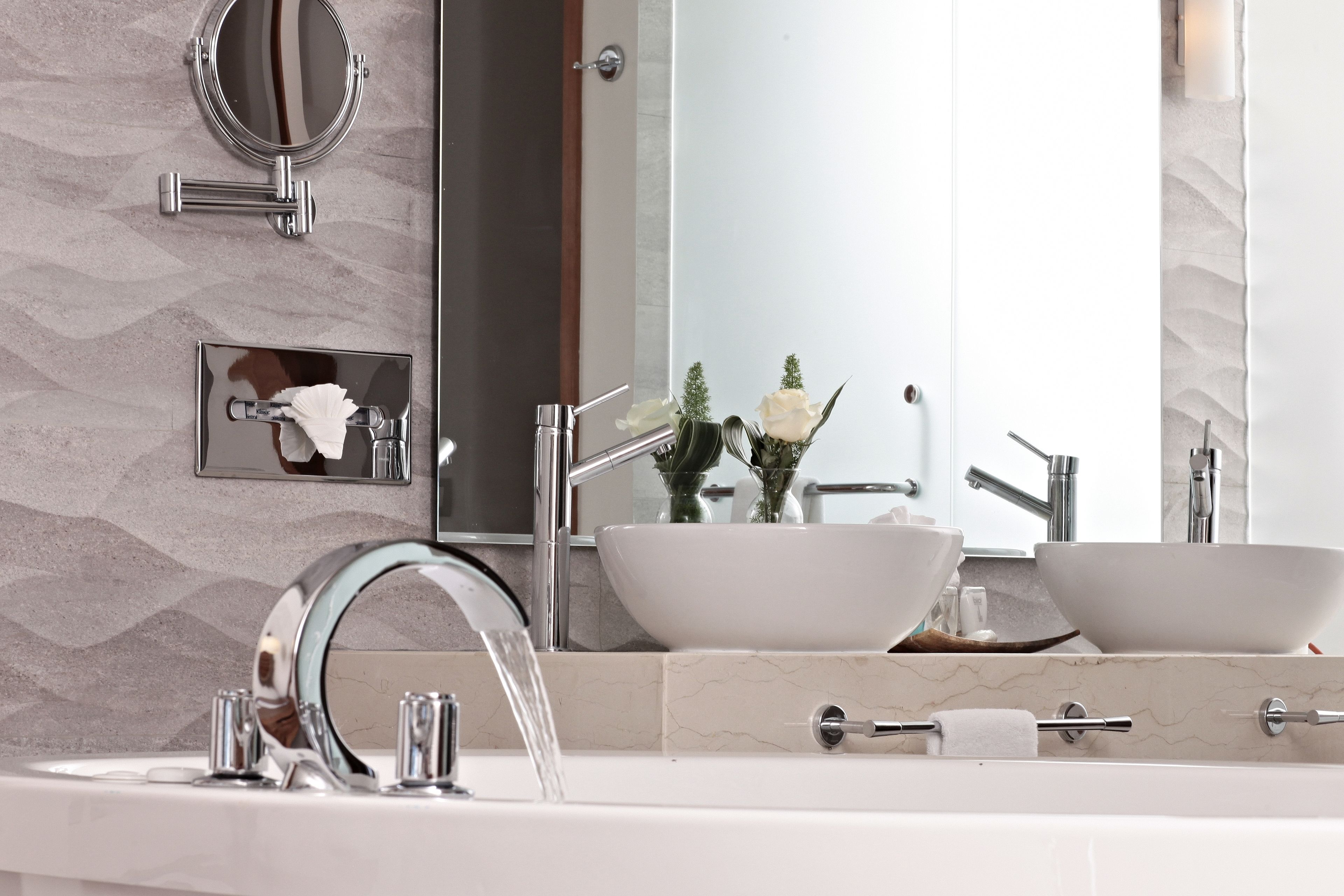 Un baño moderno con dos lavamanos, un espejo grande y un perchero para toallas.