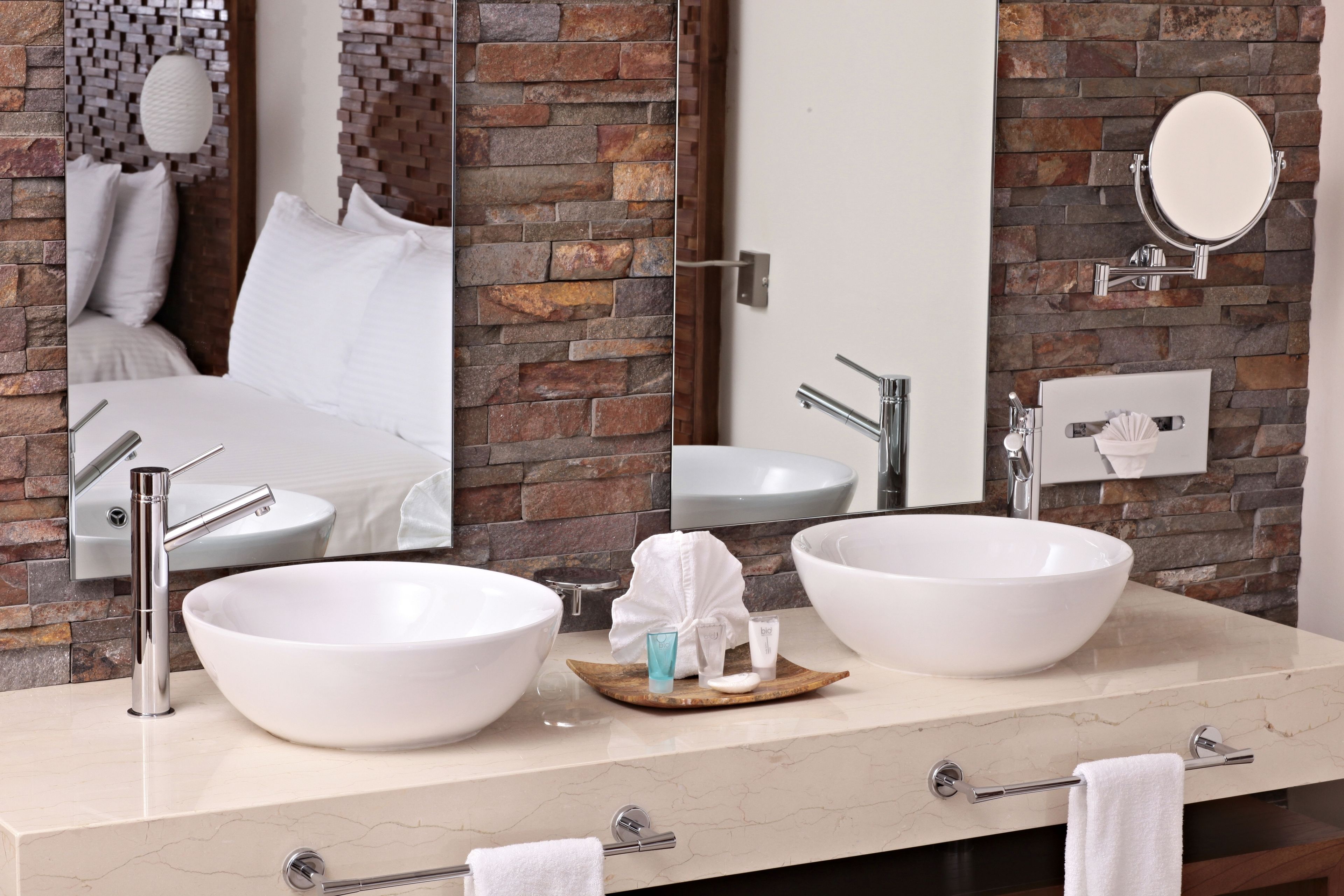 A bathroom with two large white sinks, a mirror, and a towel rack.