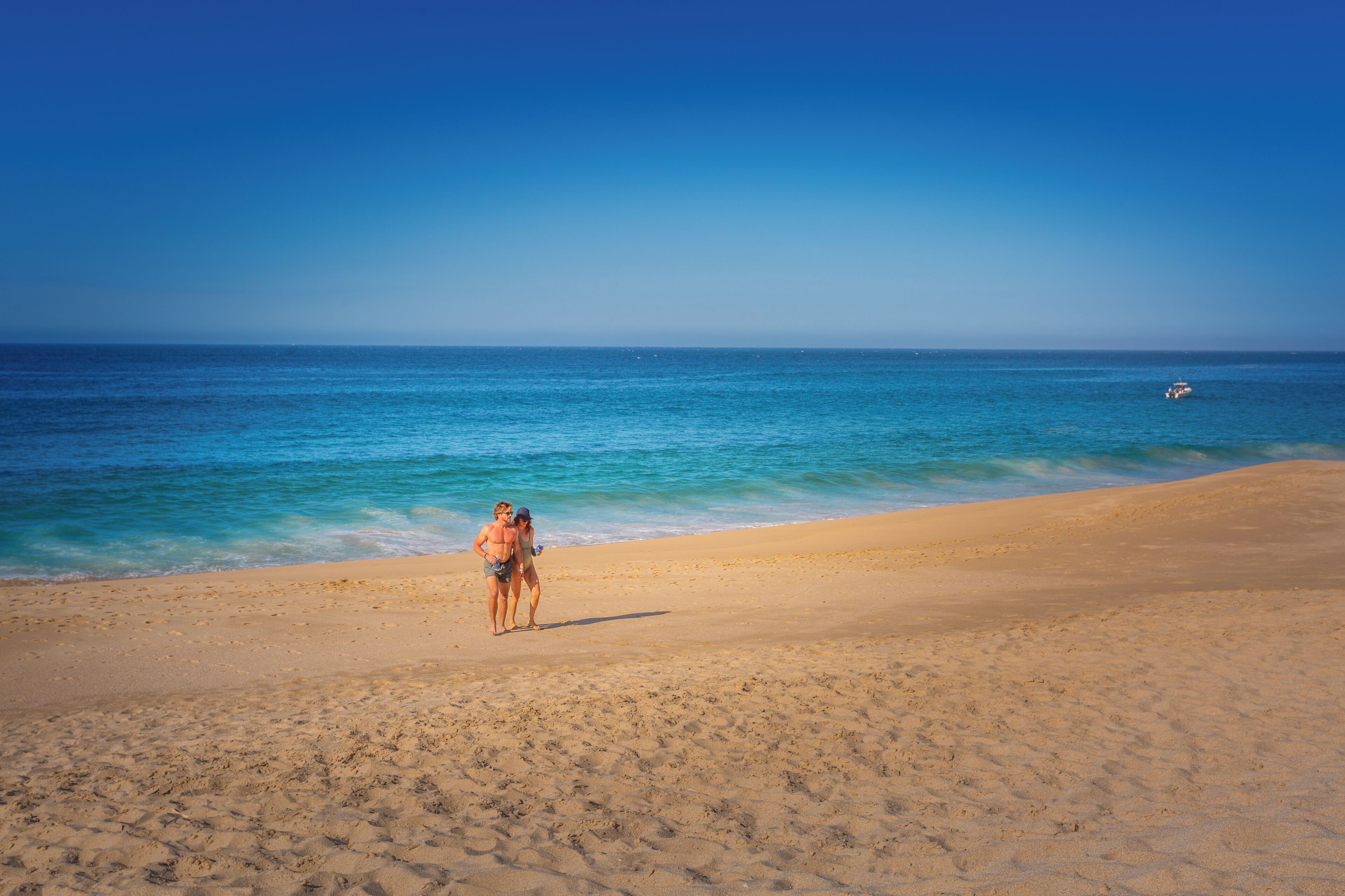 Ein Strand mit blauem Himmel und ruhiger See.