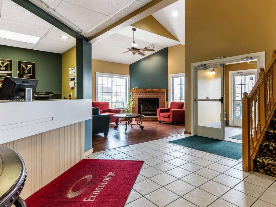 A hotel reception area with a desk, computer, and framed awards on the wall.