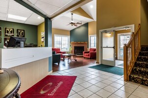 A hotel reception area with a desk, computer, and framed awards on the wall.