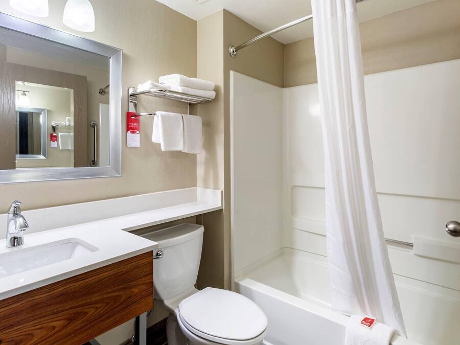 Ein Badezimmer mit Waschbecken, Spiegel, Toilette und Duschbereich.