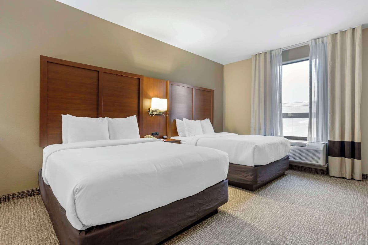 Camas con pillow-top, escritorio y cortinas blackout