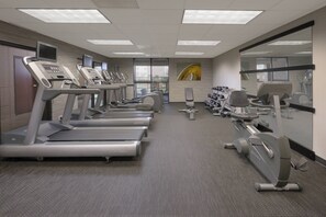 A gym with treadmills, stationary bikes, and dumbbells. - Courtyard by Marriott Houston Northwest (Houston)