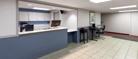 A clean, modern office with a reception desk, computer, and seating area.