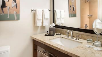Un baño de hotel con dos lavamanos, un espejo grande y un perchero para toallas.