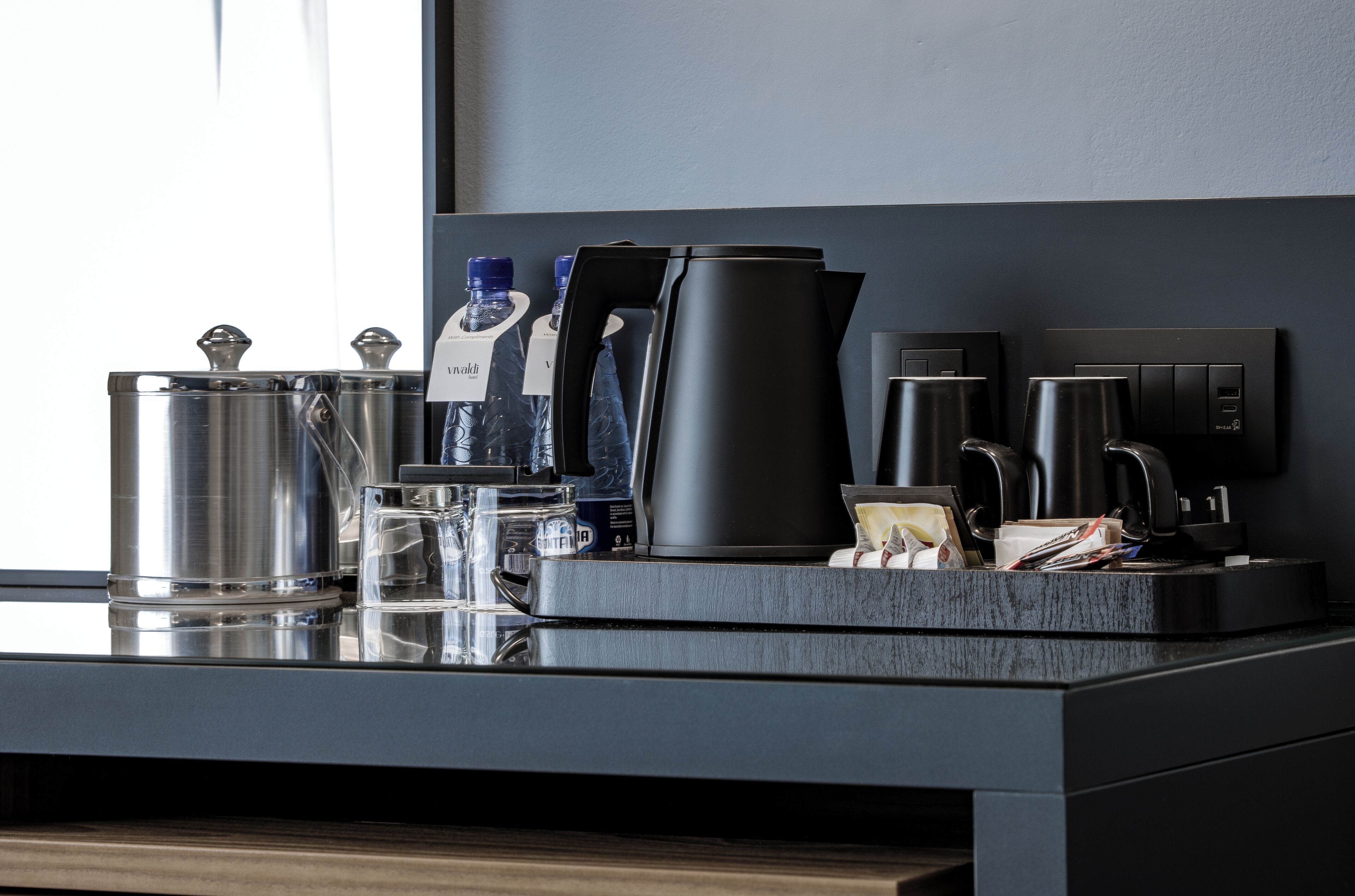 A modern kitchen counter with a coffee maker, kettle, and various kitchen items.