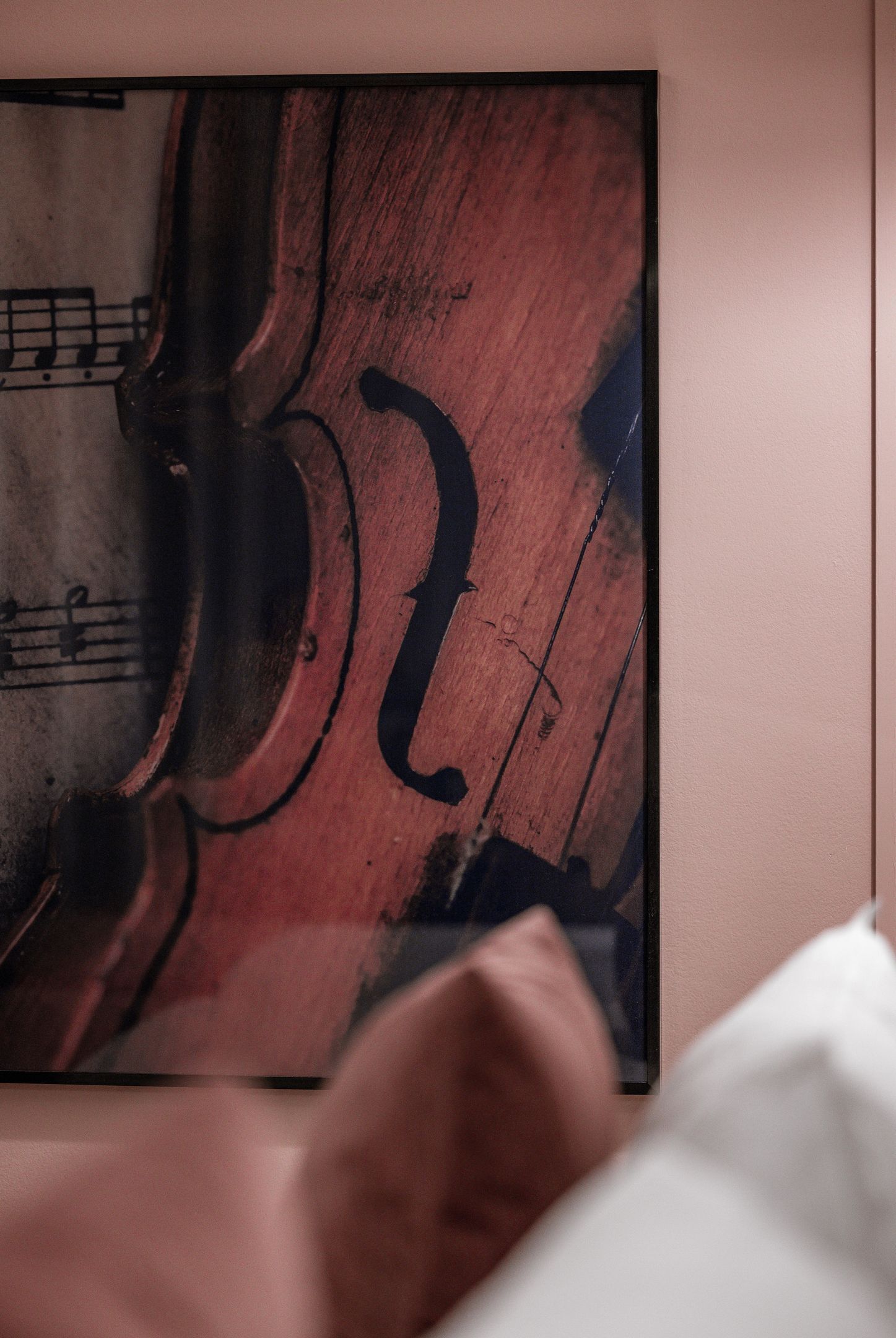 A framed artwork of a violin on a wall.