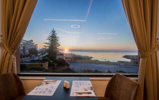 A table with menus and a view of the sunset over the sea.