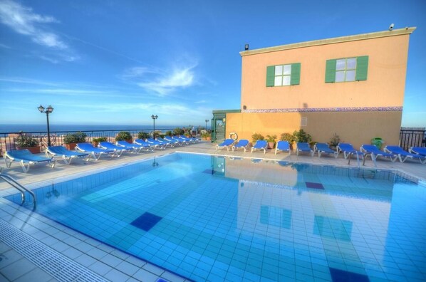 Piscine extérieure, parasols de plage, chaises longues