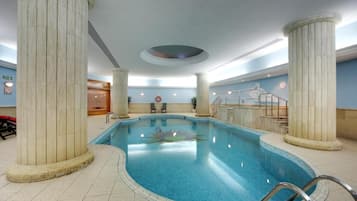 Una piscina al aire libre, sombrillas, sillones reclinables de piscina