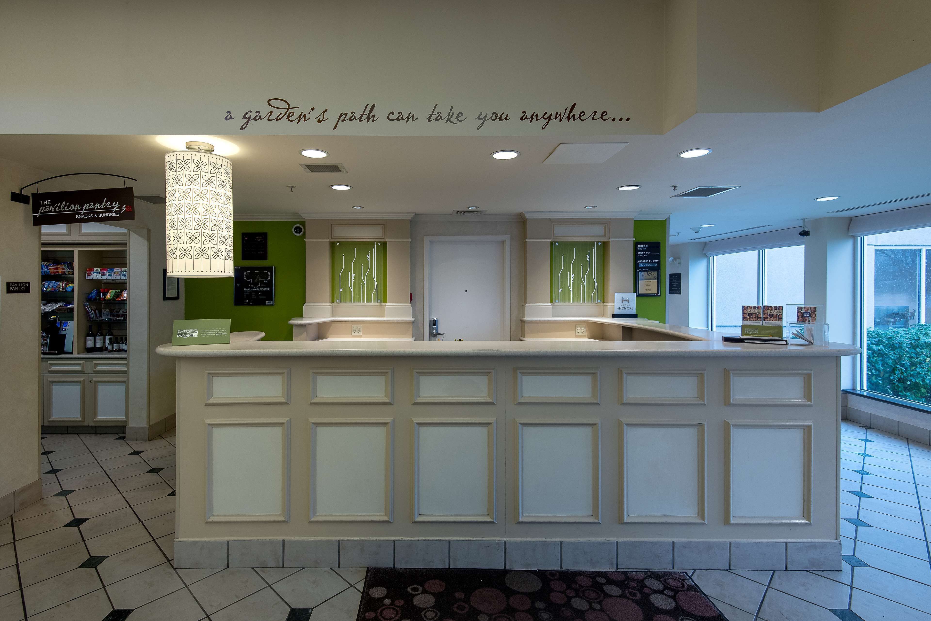 A reception area with a counter, a sign for 'The Revolution Pantry', and a wall with a quote.