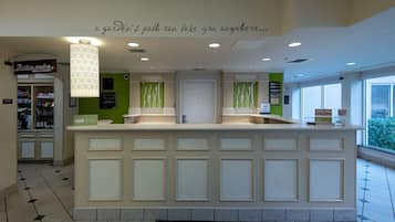 A reception area with a counter, a sign for 'The Revolution Pantry', and a wall with a quote.