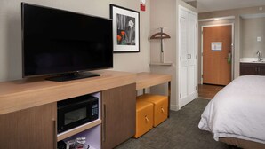 A hotel room with a flat-screen TV, a framed picture, a lamp, a microwave, and a bed. - Hampton Inn Phoenix/Glendale/Peoria (Peoria)