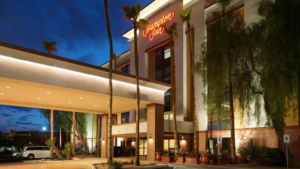 A Hampton Inn hotel with a modern facade, palm trees, and a welcoming entrance. - Hampton Inn Phoenix/Glendale/Peoria (Peoria)