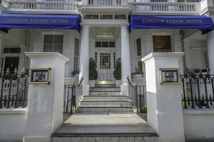 Der Eingang des London Lodge Hotels mit einer prachtvollen Fassade, weißen Säulen und einer Marmortreppe, die zum Eingang führt.