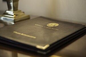 A book titled "London Lodge Hotel" with a gold embossed logo.