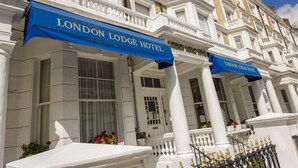 The London Lodge Hotel facade with white columns, large windows, and blue awnings. - London Lodge Hotel (London)