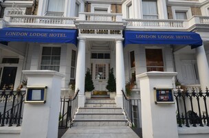 Der Eingang des London Lodge Hotels mit einer prachtvollen Fassade, Säulen und einer blauen Markise.