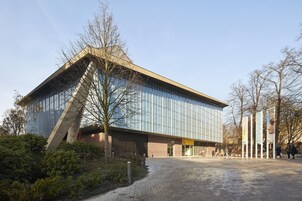 Ein modernes Gebäude mit Glasfassade und einer markanten, ungewöhnlichen Struktur.