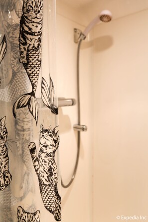 A bathroom with a shower and a glass door featuring a cat pattern. - Colliers Hotel (London)