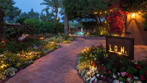 A garden pathway leading to a building with a sign that reads "LON's." - Hermosa Inn (Paradise Valley)