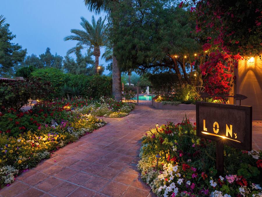 A garden pathway leading to a building with a sign that reads "LON's."