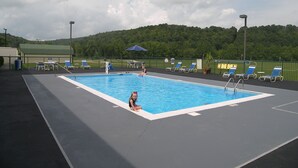 A swimming pool with lounge chairs and a green fence. - Baymont by Wyndham Mount Vernon Renfro Valley (Mount Vernon)