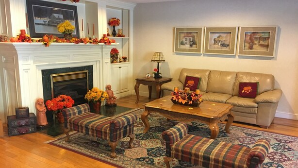 A living room with a fireplace, a sofa, two armchairs, a coffee table, and a rug. - Baymont by Wyndham Mount Vernon Renfro Valley (Mount Vernon)