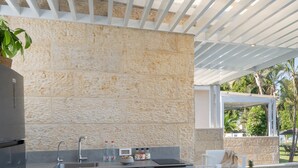 A modern kitchen with a stone backsplash, grey cabinets, and a built-in sink. - Ein Gev Holiday Resort (Emek HaYarden)