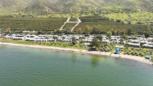 A coastal resort with villas, a beach, and a mountainous backdrop. - Ein Gev Holiday Resort (Emek HaYarden)