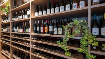 Una bodega con estantes llenos de botellas de vino y copas.