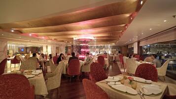 A spacious restaurant with multiple dining areas, each with tables set for guests.