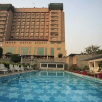 Un hotel con piscina, varios pisos y un cartel con caracteres chinos.