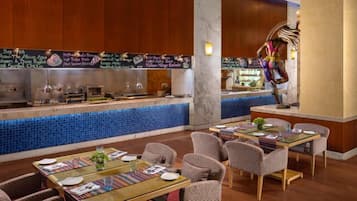 Un ristorante con un'area bar rivestita di piastrelle blu, pannelli in legno e diverse opzioni di seduta tra cui tavoli e sedie.