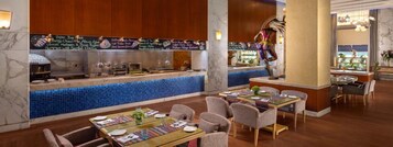 Un ristorante con un'area bar rivestita di piastrelle blu, pannelli in legno e diverse opzioni di seduta tra cui tavoli e sedie.