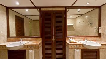 Un baño con dos lavamanos, un espejo grande y una ducha.