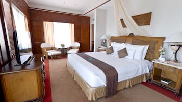 Une chambre d’hôtel avec un grand lit, une télévision, un bureau et une chaise.
