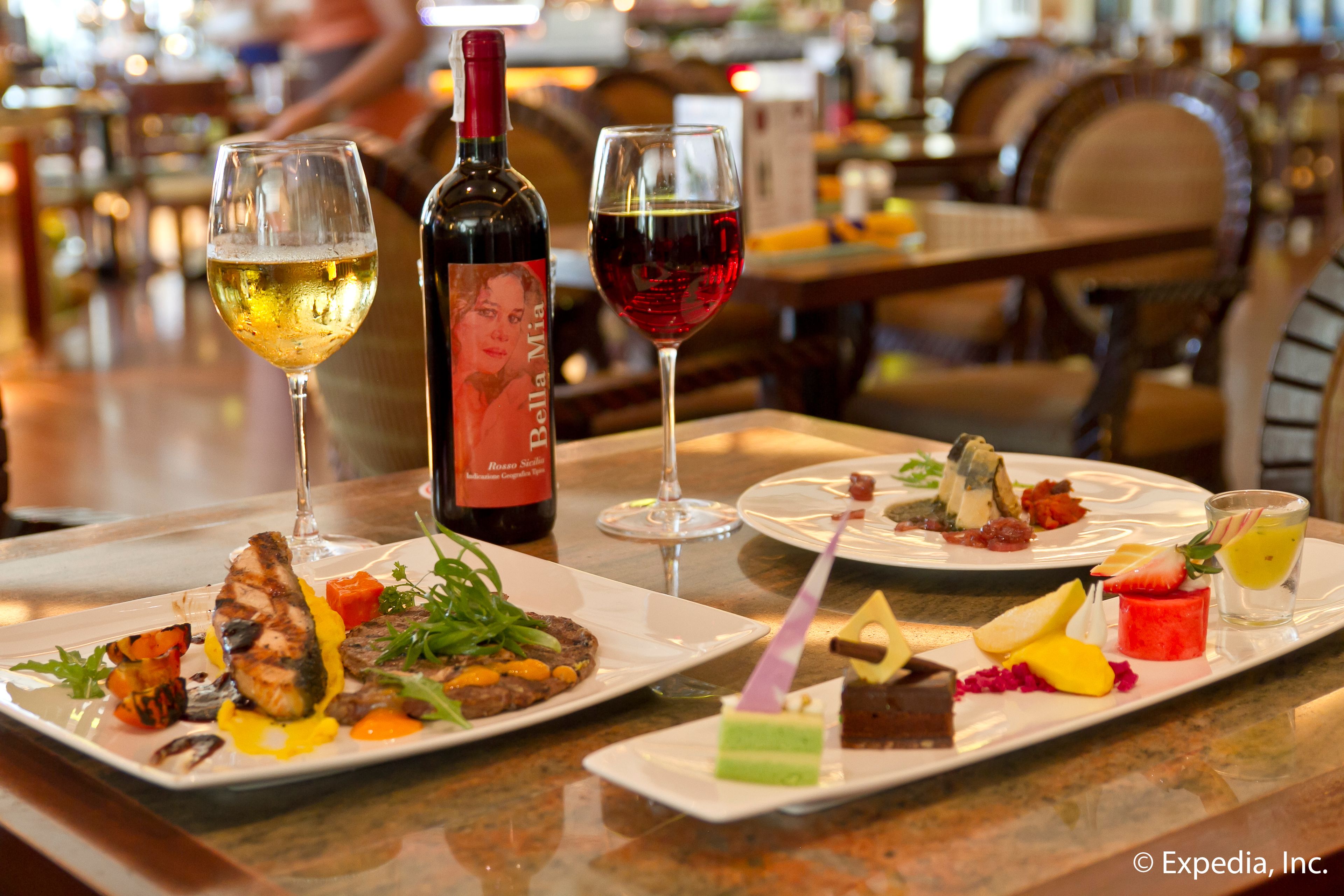 Una mesa de comedor con diversos platos y copas de vino.